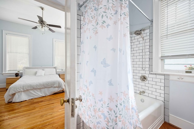 bathroom featuring wood finished floors, a ceiling fan, ensuite bath, and shower / tub combo