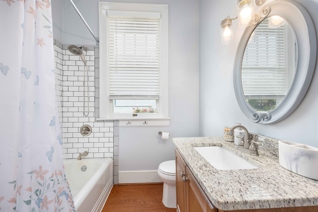 bathroom with baseboards, a wealth of natural light, toilet, and vanity