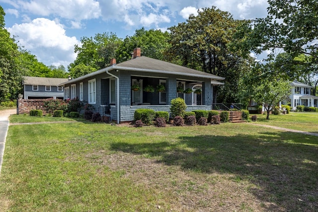 view of property exterior featuring covered porch, a chimney, and a yard