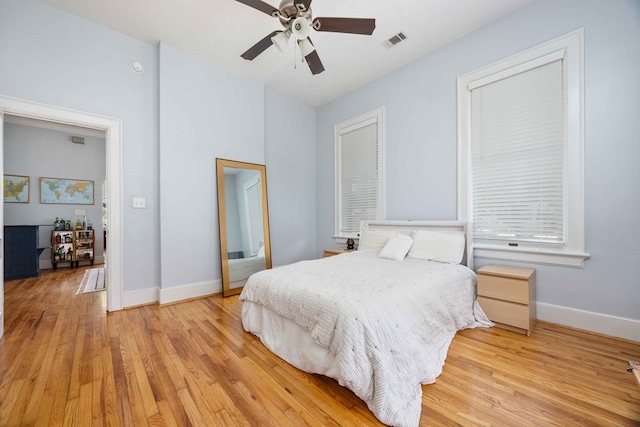bedroom with baseboards, visible vents, ceiling fan, and light wood-type flooring