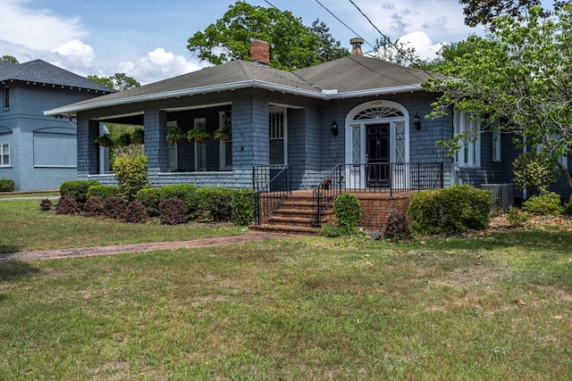 view of front of property featuring central air condition unit, a chimney, and a front lawn