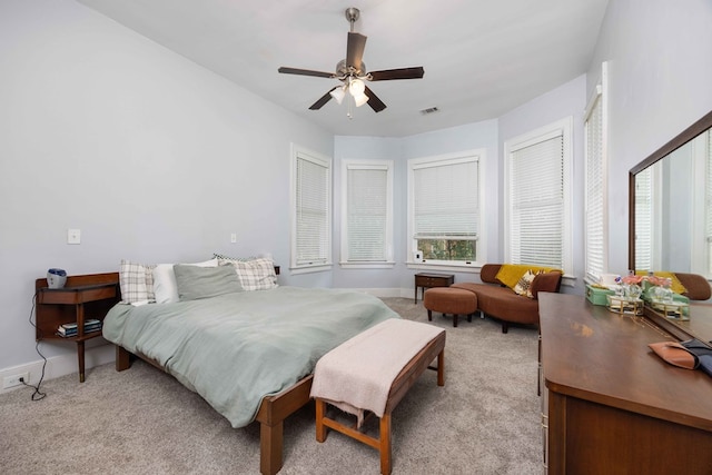 bedroom with baseboards, light colored carpet, ceiling fan, and visible vents