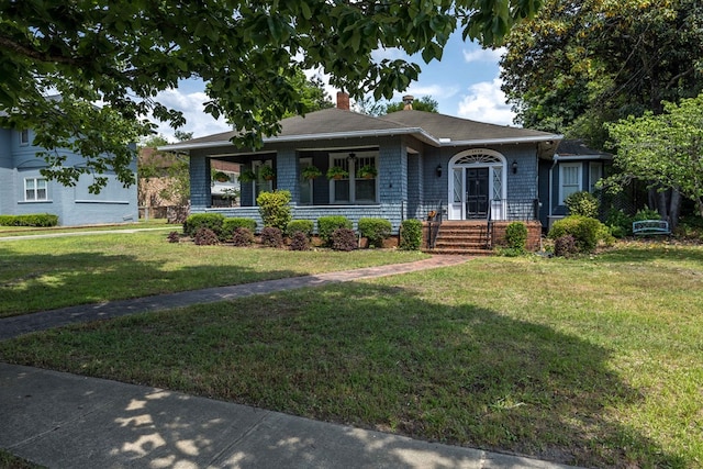 view of front of house featuring a chimney and a front lawn