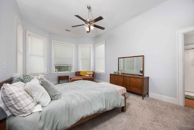 bedroom featuring baseboards, light carpet, a ceiling fan, and visible vents