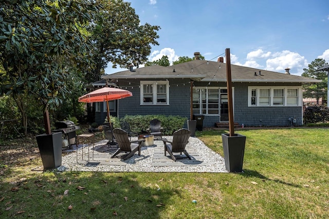back of house with a yard, a patio area, and an outdoor fire pit