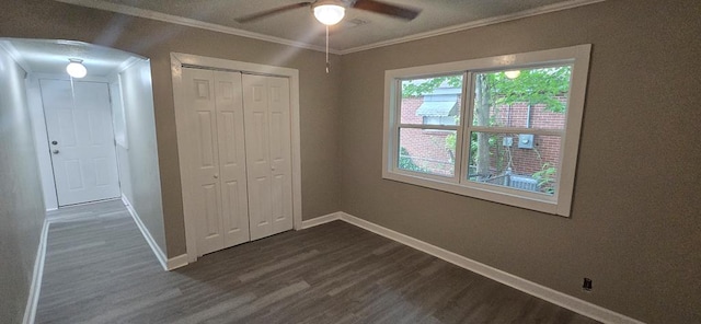 3315 Urban Ave, Columbus, GA 31907 - unfurnished bedroom featuring dark wood finished floors, crown molding, a closet, arched walkways, and a ceiling fan