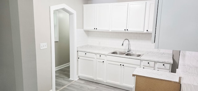 3315 Urban Ave, Columbus, GA 31907 - kitchen with white cabinets, light wood finished floors, tasteful backsplash, and light stone countertops