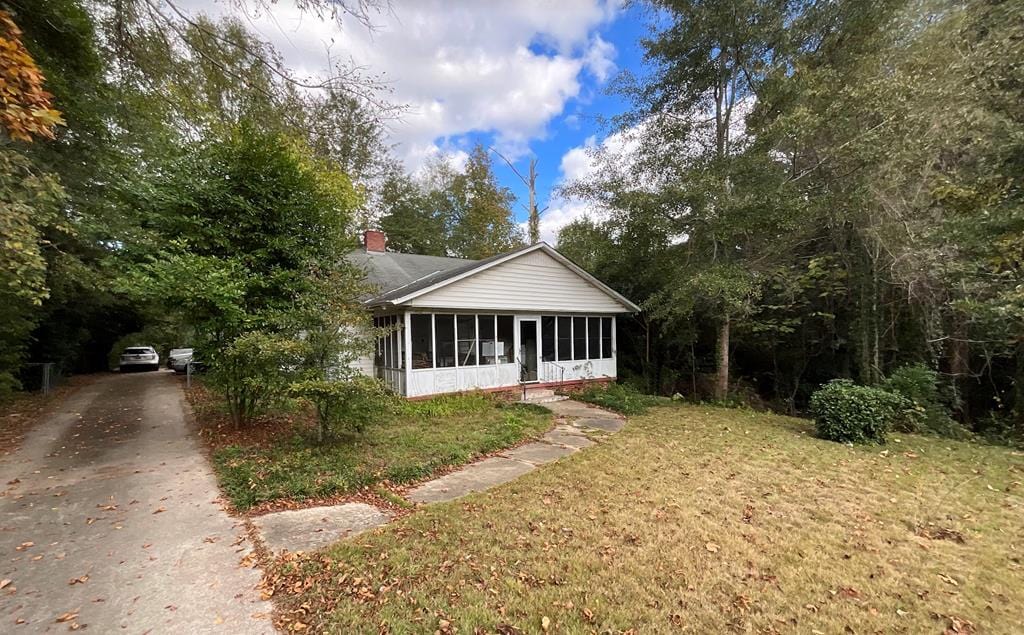 view of front of house featuring a front lawn and a sunroom