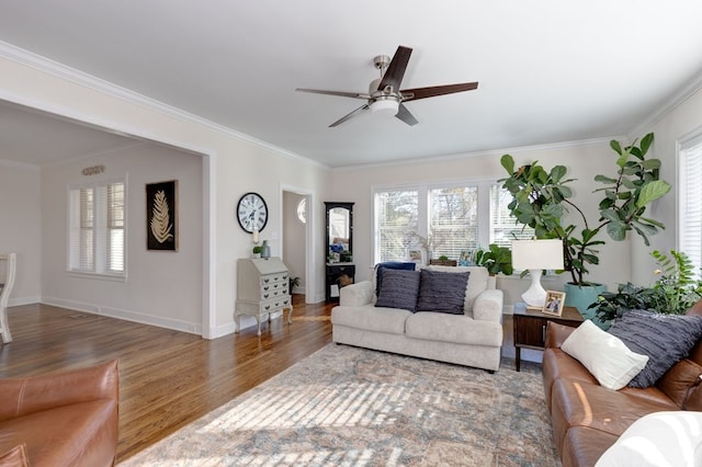 living room featuring dark hardwood / wood-style flooring, a wealth of natural light, crown molding, and ceiling fan