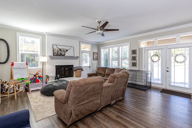 living room with dark hardwood / wood-style flooring, a brick fireplace, ceiling fan, and ornamental molding