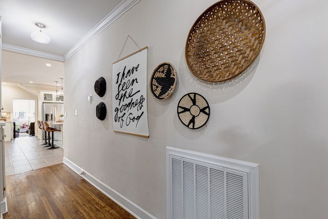 hallway featuring light wood-type flooring and crown molding