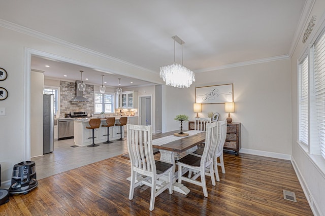 dining space with dark hardwood / wood-style flooring, a notable chandelier, and ornamental molding