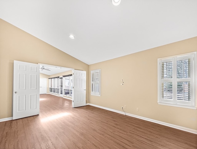 empty room with recessed lighting, vaulted ceiling, baseboards, and wood finished floors