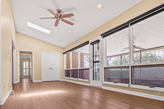 unfurnished room with lofted ceiling with skylight, ceiling fan, wood finished floors, and recessed lighting