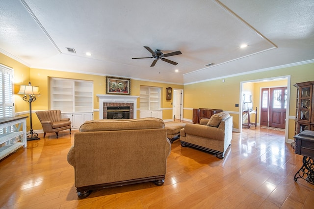 5 Mallard Ct, Midland, GA 31820 - living area featuring built in shelves, light wood-style floors, ceiling fan, a brick fireplace, and ornamental molding