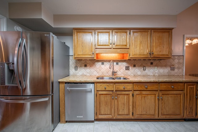 5 Mallard Ct, Midland, GA 31820 - kitchen featuring stainless steel appliances, brown cabinetry, backsplash, light tile patterned floors, and light stone countertops