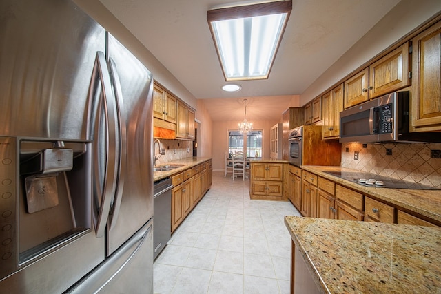 5 Mallard Ct, Midland, GA 31820 - kitchen with appliances with stainless steel finishes, a chandelier, a peninsula, decorative backsplash, and light tile patterned floors