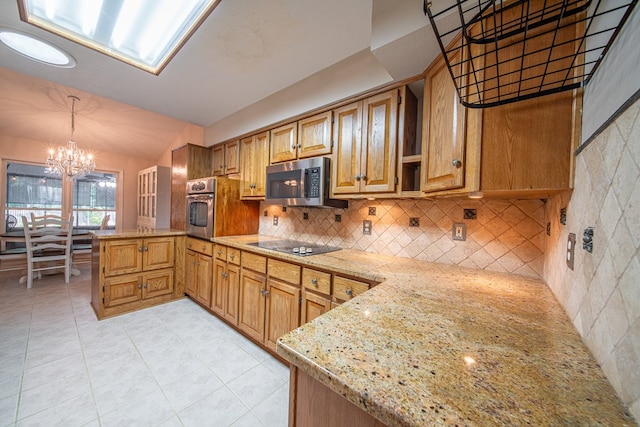 5 Mallard Ct, Midland, GA 31820 - kitchen with a peninsula, stainless steel appliances, a chandelier, light stone counters, and light tile patterned floors