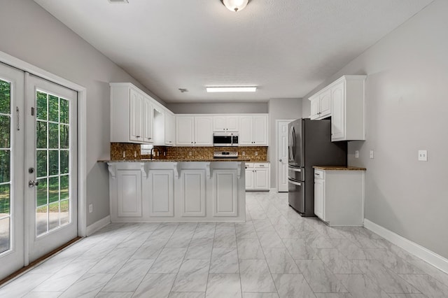 240 Lee Road 2099, Phenix City, AL 36870 - kitchen featuring appliances with stainless steel finishes, french doors, a peninsula, light marble finish floors, and baseboards