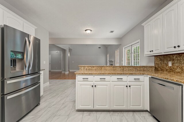 240 Lee Road 2099, Phenix City, AL 36870 - kitchen with stainless steel appliances, a peninsula, white cabinets, and light stone counters