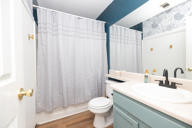 bathroom featuring vanity, shower / bath combo with shower curtain, toilet, visible vents, and wood finished floors