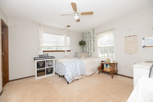 bedroom with multiple windows, ceiling fan, light colored carpet, and visible vents