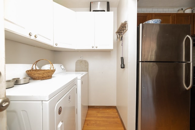 washroom featuring cabinet space, independent washer and dryer, and light wood-type flooring