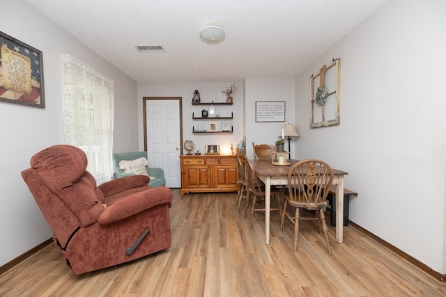 dining room with visible vents, light wood-style flooring, and baseboards