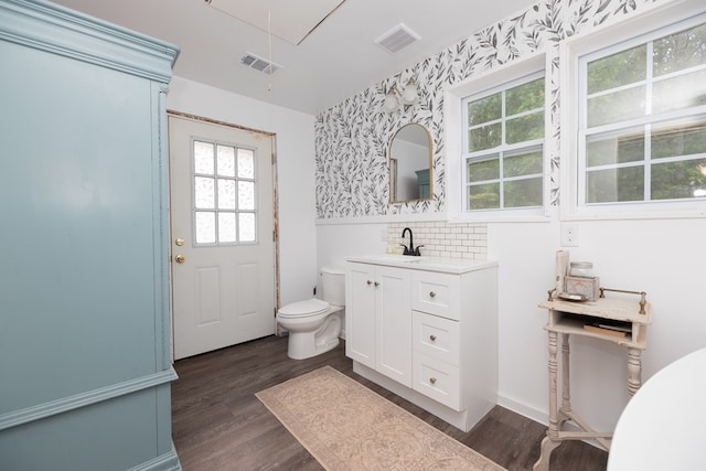 bathroom featuring visible vents, wood finished floors, toilet, and vanity