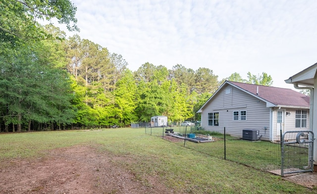 view of yard with cooling unit, a shed, an outdoor structure, and fence