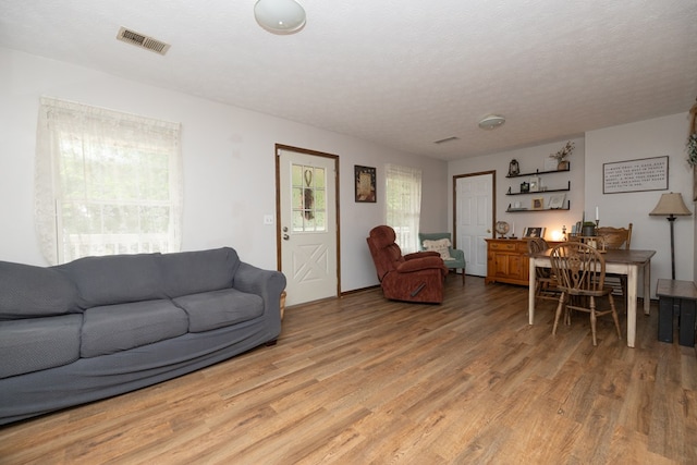 living area with visible vents and light wood-style flooring
