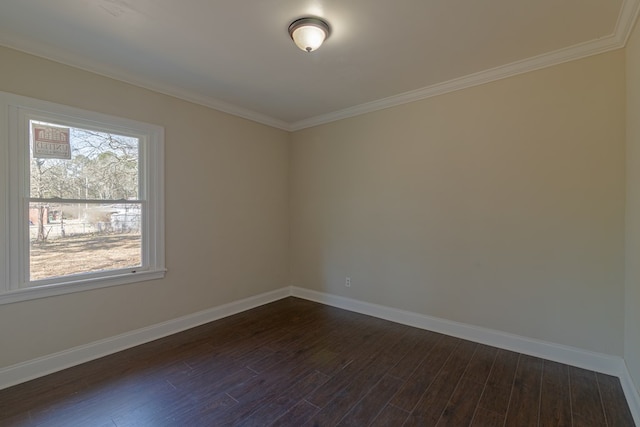 spare room featuring baseboards, dark wood finished floors, and crown molding