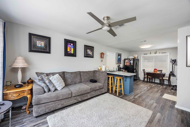 living room featuring dark hardwood / wood-style floors and ceiling fan