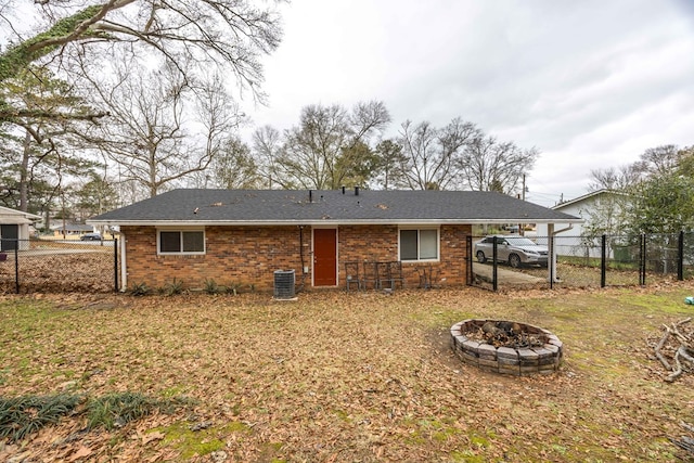 back of house with central AC unit and an outdoor fire pit