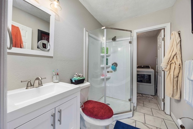 bathroom with vanity, a textured ceiling, a shower with door, washer / clothes dryer, and toilet