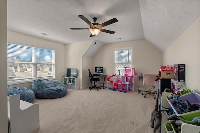 game room featuring carpet, visible vents, a ceiling fan, vaulted ceiling, and a textured ceiling