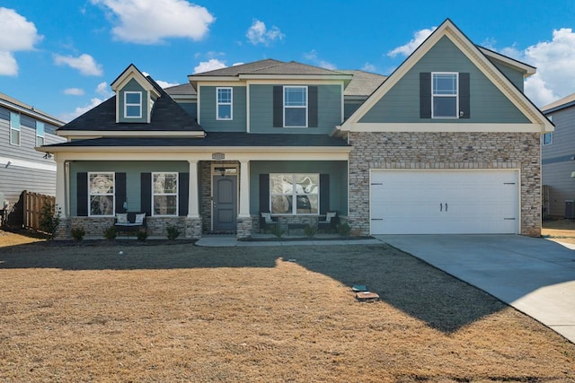 craftsman inspired home with a porch, concrete driveway, an attached garage, cooling unit, and a front lawn