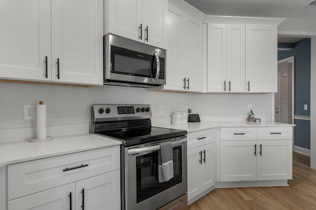 kitchen with stainless steel appliances, light wood finished floors, light countertops, and white cabinets