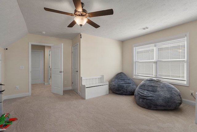 interior space with a textured ceiling, baseboards, visible vents, and light colored carpet