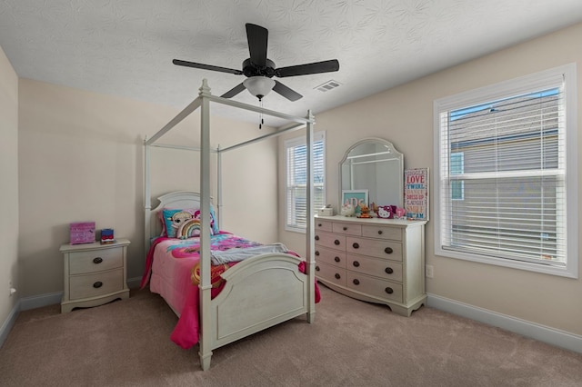 bedroom featuring a textured ceiling, light colored carpet, a ceiling fan, baseboards, and visible vents