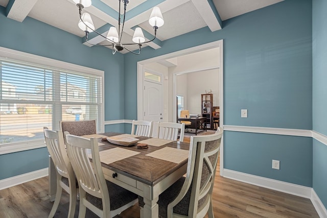 dining room with a notable chandelier, baseboards, and wood finished floors