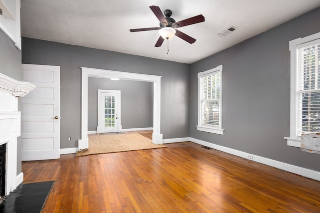 1024 18th St, Columbus, GA 31901 - unfurnished living room featuring hardwood / wood-style floors, a ceiling fan, a fireplace with flush hearth, and healthy amount of natural light