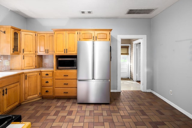 1024 18th St, Columbus, GA 31901 - kitchen with stainless steel appliances, glass insert cabinets, and decorative backsplash
