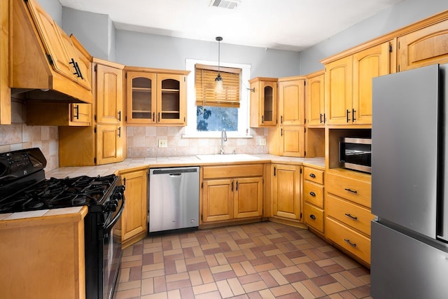 1024 18th St, Columbus, GA 31901 - kitchen with stainless steel appliances, tile countertops, tasteful backsplash, premium range hood, and glass insert cabinets