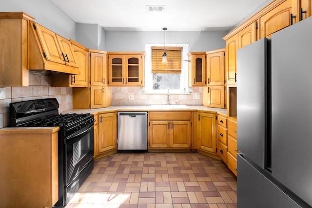 1024 18th St, Columbus, GA 31901 - kitchen featuring appliances with stainless steel finishes, light countertops, tasteful backsplash, and glass insert cabinets