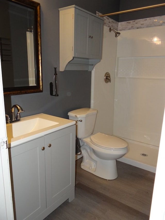 full bath featuring vanity, toilet, wood finished floors, and a shower stall