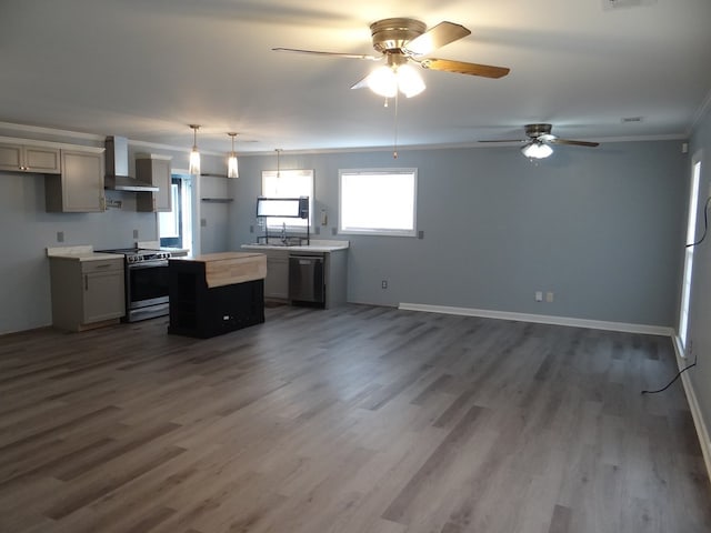 kitchen with dark wood-style floors, appliances with stainless steel finishes, wall chimney exhaust hood, and a center island