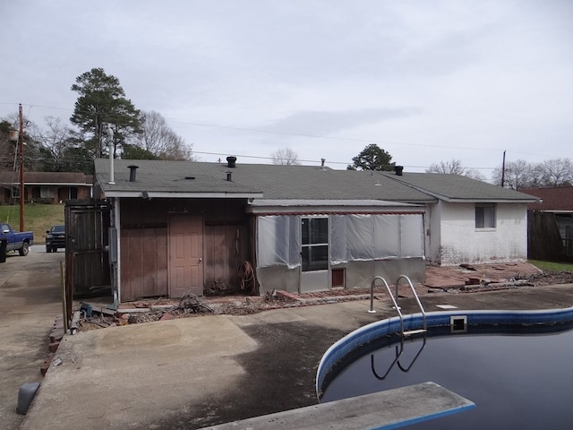 back of property featuring an outdoor pool and a patio