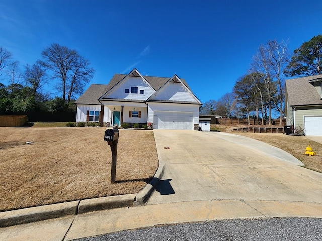 view of front facade featuring driveway, a garage, fence, and board and batten siding