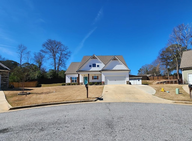 view of front of house with a garage, driveway, stone siding, and fence